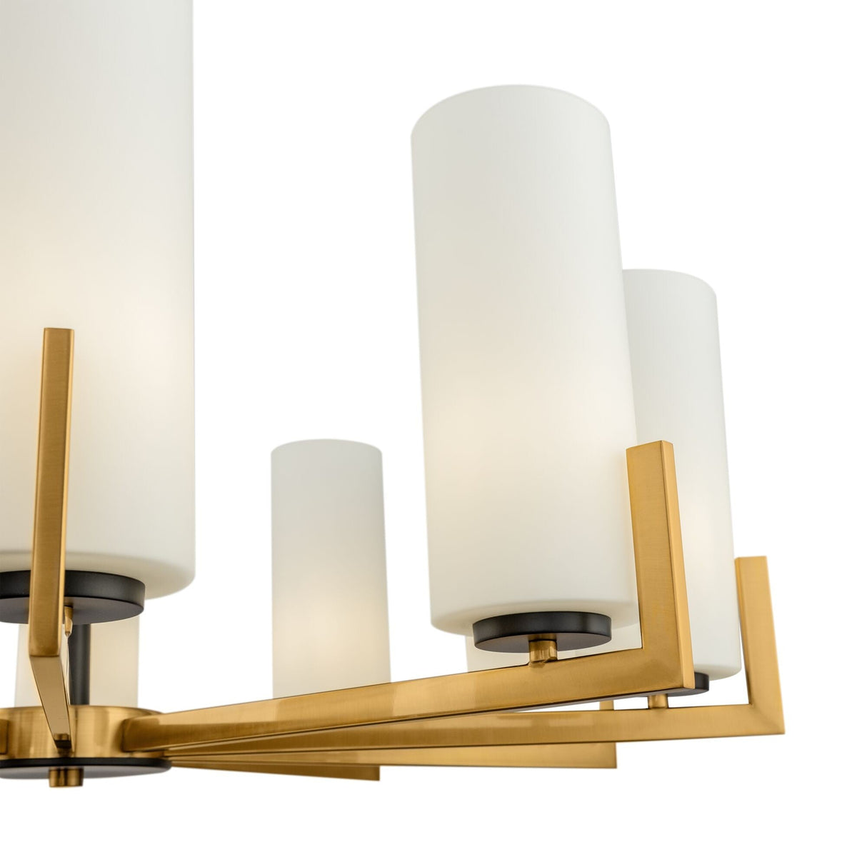 Close-up of the Fortano 10 Light Chandelier - Brass, featuring matte white cylindrical glass shades within a geometric brass frame. Its sleek and contemporary design showcases three visible light fixtures highlighting its modern geometry.