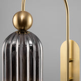 Close-up of the Antic wall light in gold with grey glass, emphasizing its polished gold finish and textured glass.