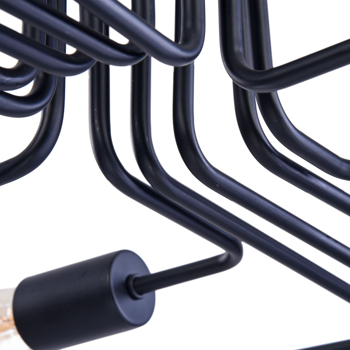 The Gilbert 12 Light Semi-Flush in black showcases an industrial-style design with multiple bent metal rods forming geometric patterns. The partially visible bulb emphasizes its modern aesthetic and exposed bulb design.