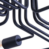 The Gilbert 12 Light Semi-Flush in black showcases an industrial-style design with multiple bent metal rods forming geometric patterns. The partially visible bulb emphasizes its modern aesthetic and exposed bulb design.