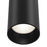 The close-up of the Focus Single Phase UNITY Track Pendant Light - Black reveals a glowing bulb inside. Emitting bright white light, it highlights the smooth matte finish of the industrial design black cylindrical ceiling light.