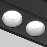 In a close-up, two round recessed Points LED Linear Track Lights for Magnetic Exility emit a bright 3000K glow from the dark ceiling. The neutral gray background enhances the textured surface and understated elegance of this 18W black design.