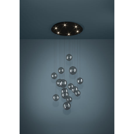 Espardello 6-light pendant with round black steel canopy and clear glass globes clustered at staggered heights on fine wires, shown against a dark teal wall.