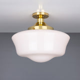 Ethrina Glass Semi Flush Ceiling Light with white opal schoolhouse-style glass shade and polished brass fitter, mounted close to the ceiling on a round brass plate against a plain grey background.