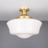 Ethrina Glass Semi Flush Ceiling Light with a white opal schoolhouse-style glass shade and satin brass fitter on a short stem, against a plain grey background.