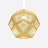 The Rango Large Pendant Light - Gold showcases a geometric design crafted from perforated metal that casts a warm glow. This elegant fixture creates intricate patterns of light and shadow and hangs by a slender black cord, contrasting beautifully against a simple white backdrop.