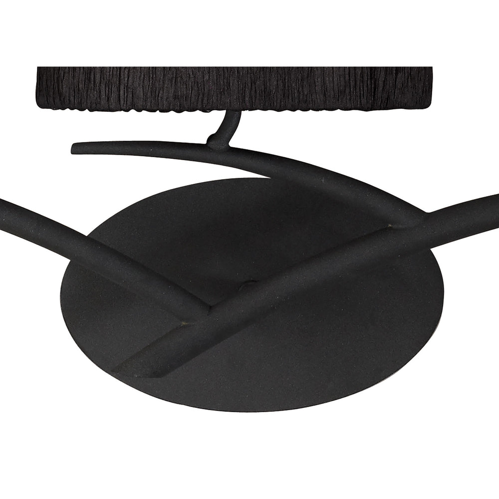 Close-up of the Eve wall light's circular anthracite backplate with curved steel arms and pleated black fabric shade above.