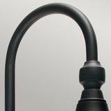 Close-up of a sleek, modern black curved metal fixture against a gray background, reminiscent of the Firenze Outdoor 1 Light Wall Lantern - Black. The fixture boasts a smooth finish and features a cylindrical detail near the curve.