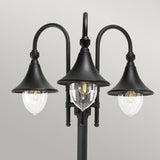 The Firenze 3 Light Lamp Post - Black boasts a sleek black finish and three elegantly curving arms, each supporting a dome-shaped shade. The central transparent shade showcases a filament bulb, with the remaining shades in an opaque design. Ideal for adding charm to any outdoor setting against a simple gray background.