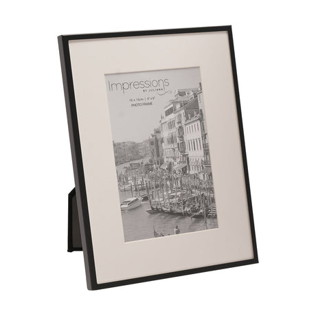 Rectangular photo frame with slim matt black metal border and wide white mount for a 6 x 4in print, shown at an angle on a plain white background.
