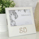 Silver aluminium rectangular photo frame for a 6 x 4in landscape photo, with a raised polished 3D "60" numeral beneath the picture, shown on a table beside a plant.