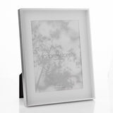 Silver shadow photo frame with white mount and rear easel, holding an 8 x 6in portrait print, shown at an angle on a plain white background.