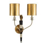 The Flambeau 2 Light Wall Light With Parchment Shade - Gold & Black showcases two gold cylindrical shades adorned with rich cream and black detailing, complemented by a central gold accent resembling a flame. The wall sconce, influenced by Mardi Gras design, features elegant curved arms emerging from a round gold base.