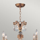 The Mignon 8 Light Chandelier - Gold & Silver showcases an exquisite gold and silver finish, adorned with radiant decorative crystal accents and sparkling crystal droplets. Candle-style light bulbs elegantly envelop the centerpiece, all gracefully suspended from an elegant chain connected to a stylish ceiling mount.
