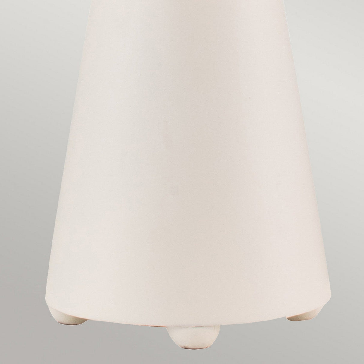 Close-up of the lower part of the Neo 1 Light Table Lamp in white and gold, showcasing its modern cone-shaped design with gold leaf accents against a light gray background. The base is designed with small rounded feet that exemplify a contemporary style.