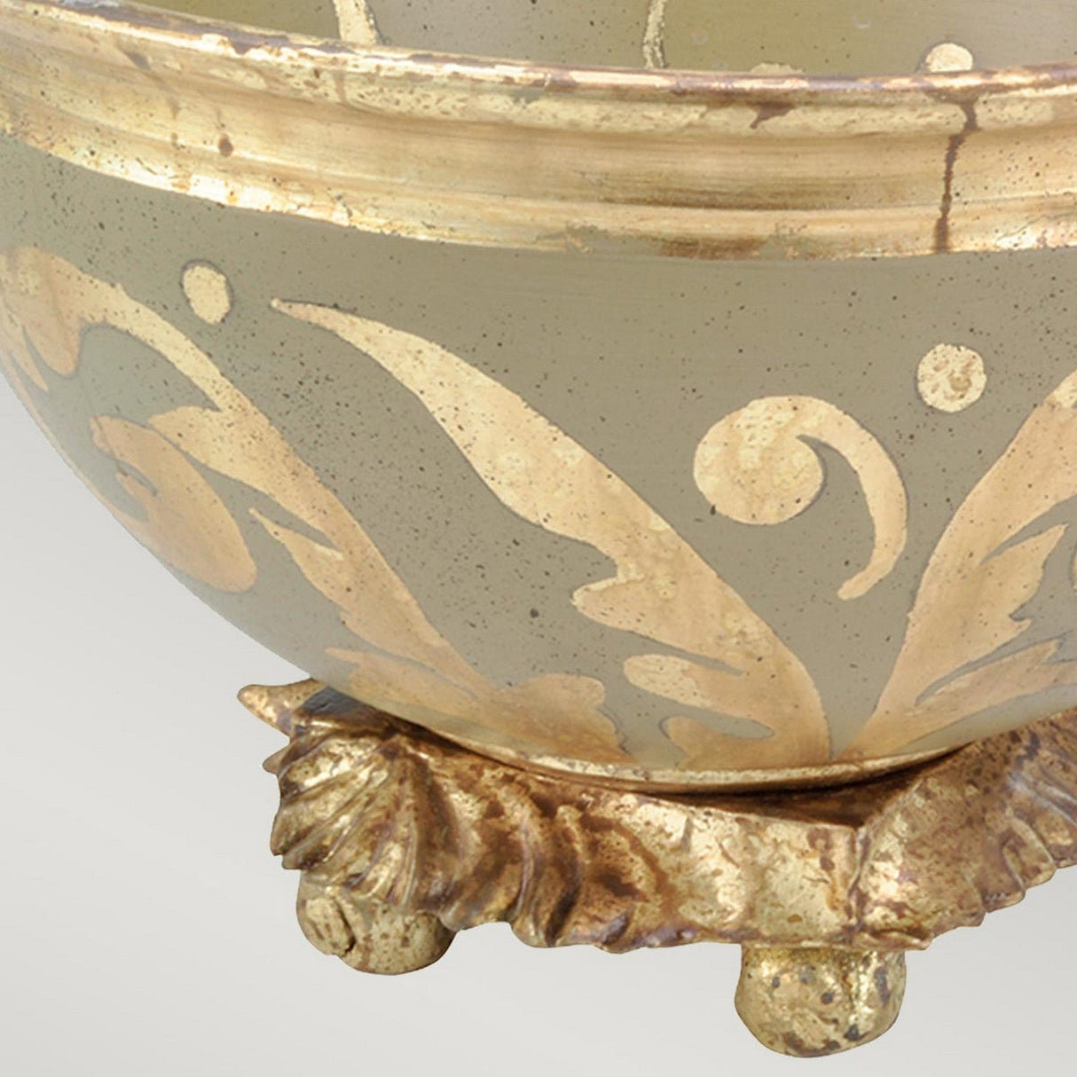 The Rocheblave Decorative Bowl showcases an antiqued gold leaf and cream pattern with swirling leaf motifs. Ideal for interior decor, it is elegantly displayed on a gilded base adorned with intricate details and has a subtly weathered finish.