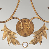 A close-up view of the Sweet Olive 2 Light Wall Light in gilded gold showcases two leaves and a circular base, with a small round crystal medallion at the center, set against a light gray background.