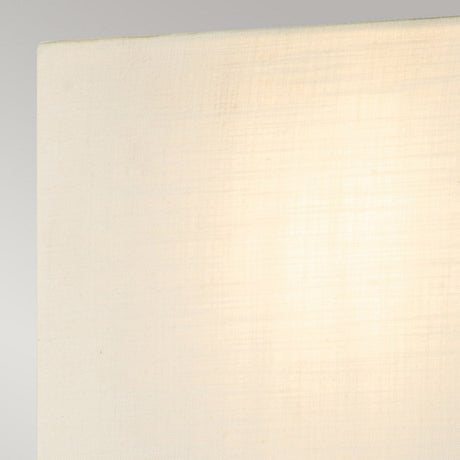 A close-up view reveals the softly lit, textured fabric surface that gently glows with warmth from the Swirl 1 Light Large Wall Light - Gold Leaf. The fabric showcases a subtle crisscross weave pattern, establishing a cozy and serene ambiance against a neutral backdrop.