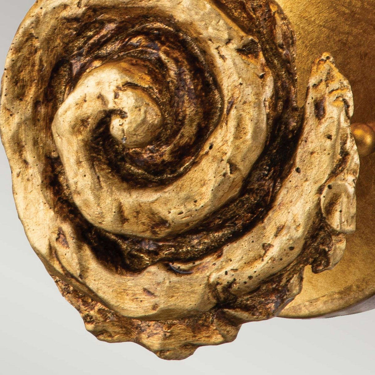 Close-up of the ornate, intricately carved spiral design on the Swirl 1 Light Large Wall Light - Gold Leaf. The swirling pattern resembles a gold leaf texture, weathered with shades of gold, brown, and black, exuding an elaborate vintage aesthetic.