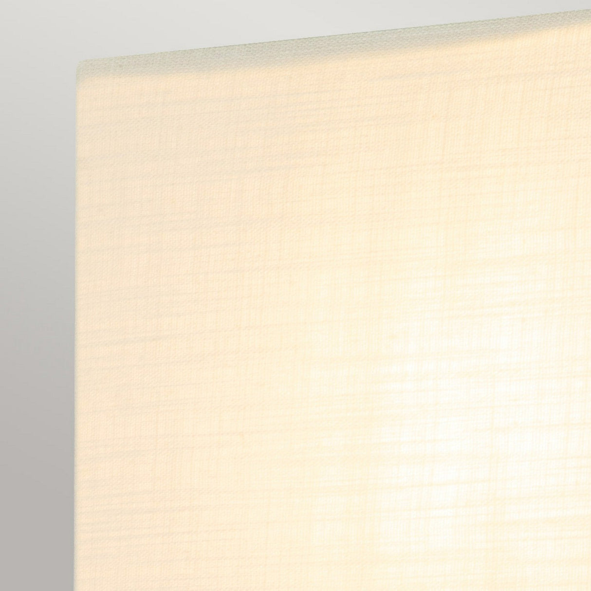 Close-up view of the Swirl 1 Light Small Wall Light - Gold Leaf featuring a softly lit, textured beige lampshade with a subtle swirl design against a gray background. The fabric displays a gentle grid pattern, beautifully diffusing the light.