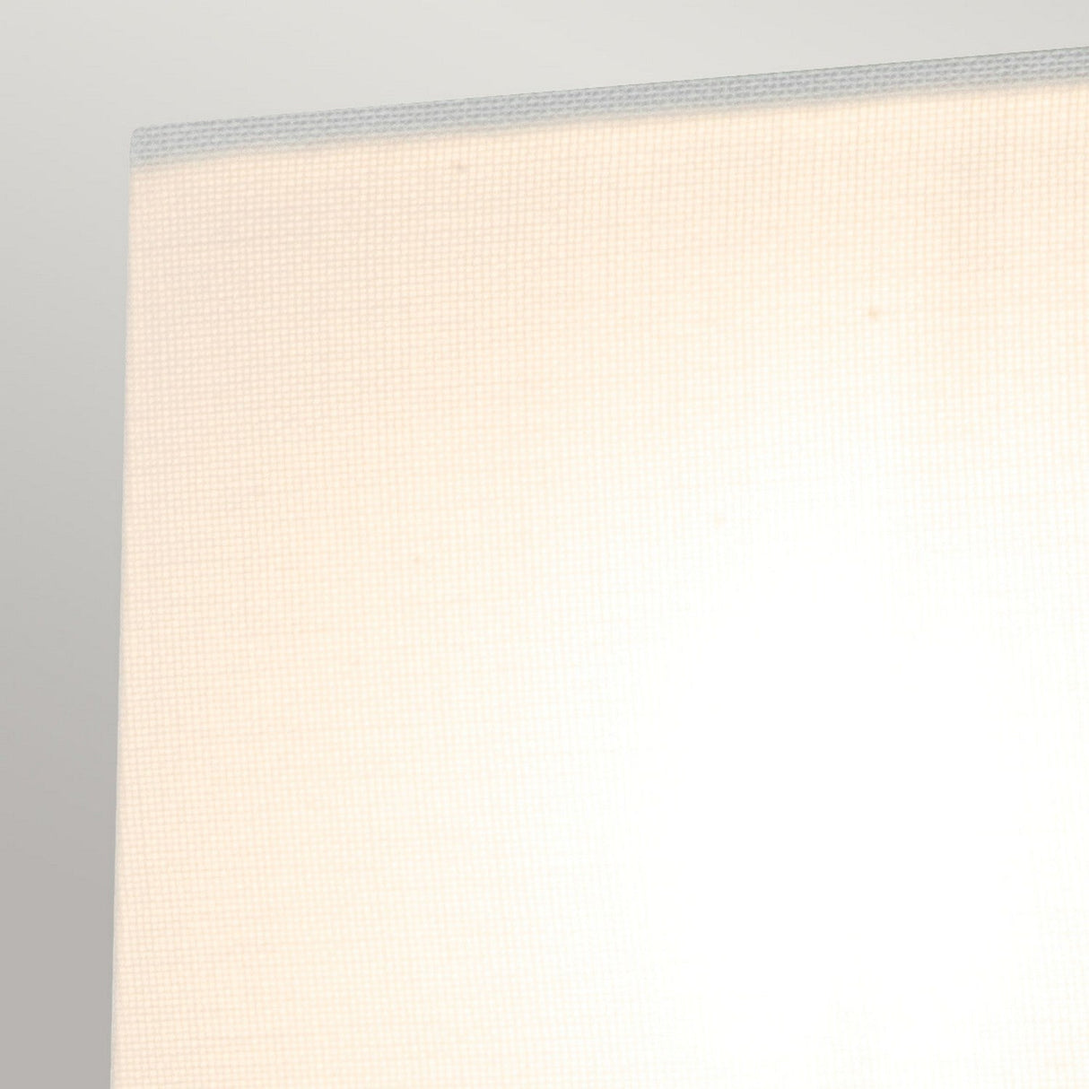 A close-up image of a beige fabric lampshade with a subtle grid pattern set against a light gray background, showcasing the texture and modern design. This lampshade perfectly complements the minimalist aesthetic of the Swirl 1 Light Small Wall Light - White.