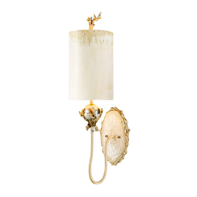 The Trellis 1 Light Wall Light in Putty Patina & Silver Leaf showcases a cream-colored cylindrical shade with gold accents and a decorative branch design. Its ornate oval backplate features a curved arm enhanced by a subtle silver leaf element, adding an extra touch of sophistication.