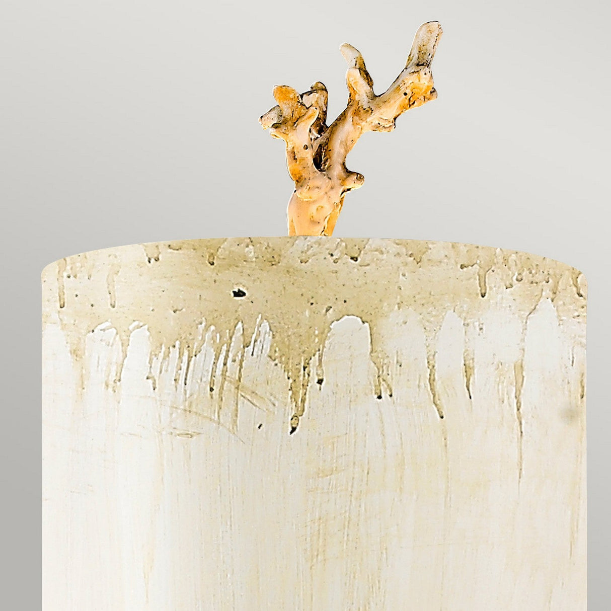 A ceramic vase with a textured cream-colored surface and brown drips showcases a hand-painted putty patina finish, complemented by an intricately shaped ceramic branch emerging from the top against a light gray background, similar to the Trellis 1 Light Wall Light featuring Putty Patina & Silver Leaf.