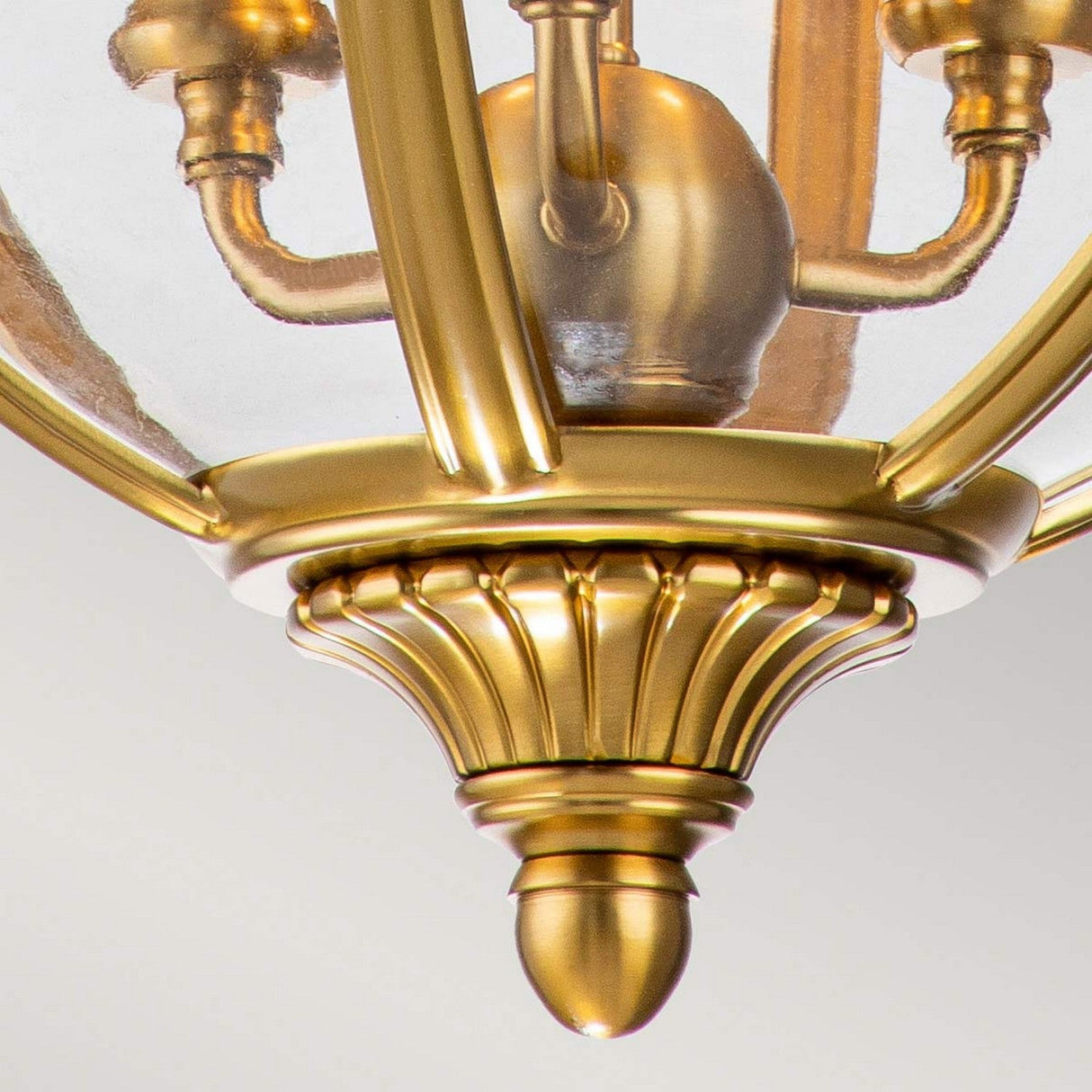 Here is a revised version of the sentence using the product data:

A close-up view of the Adams 3 Light Chandelier in burnished brass showcases its ornate, curved metal bars and intricate detailing. The Victorian design lighting enhances elegance with a smooth, polished finish, making it a luxurious fixture that adds sophistication to any space.