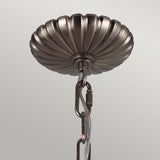The Adams 4 Light Chandelier in Antique Nickel features a decorative metallic ceiling canopy with a ridged, fluted design that evokes Victorian-inspired elegance. Its connection to a chain and cord makes it ideal for suspension. The antique nickel finish provides sophistication against a plain background.