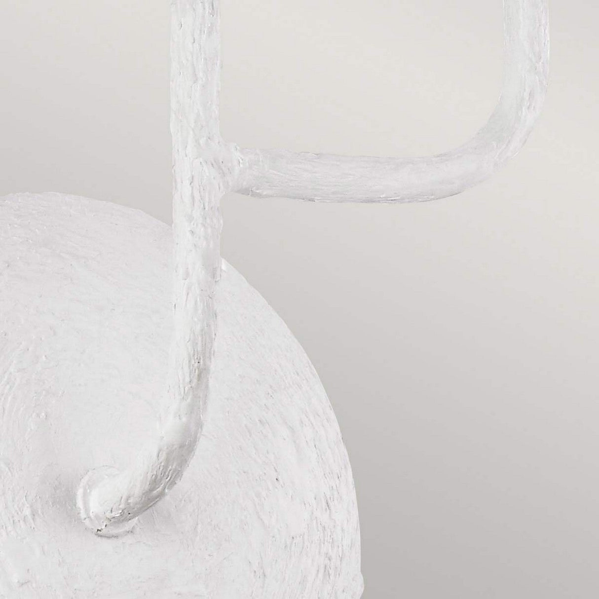 Close-up of the Annie 3 Light Wall Light in Textured Plaster White, showcasing abstract, curved and cylindrical shapes against a neutral backdrop. The composition emphasizes the rough surface and fluid form, evoking a coastal-inspired design with its textured plaster finish.