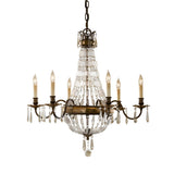 The Bellini 6 Light Chandelier in Oxidized Bronze/British Bronze presents a vintage charm with its six candle-shaped light bulbs arranged in a circular formation. It showcases intricate metalwork and dangling antique quartz crystals, all elegantly suspended by a chain, epitomizing luxury lighting.