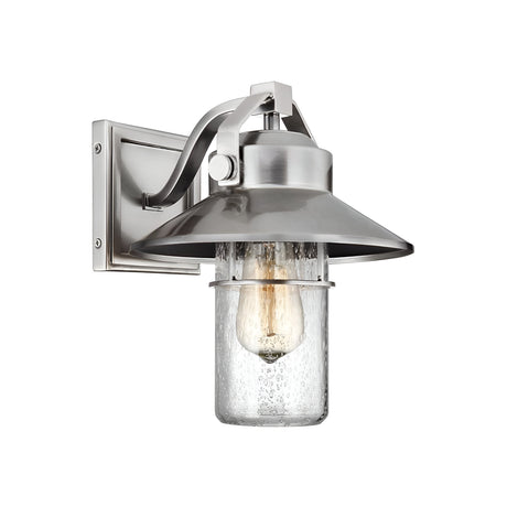 The Boynton 1 Light Outdoor Small Wall Lantern in painted brushed steel features a clear seeded glass shade and exposed bulb. This industrial-style lantern is both rustic and weather-resistant, making it ideal for porch or patio lighting.