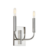 The Brianna 2 Light Wall Light in polished nickel showcases a modern design with two tall cylindrical light bulbs at the ends of gracefully curved metal arms attached to a rectangular backplate, blending contemporary elegance with minimalist style to provide ambient illumination in any space.