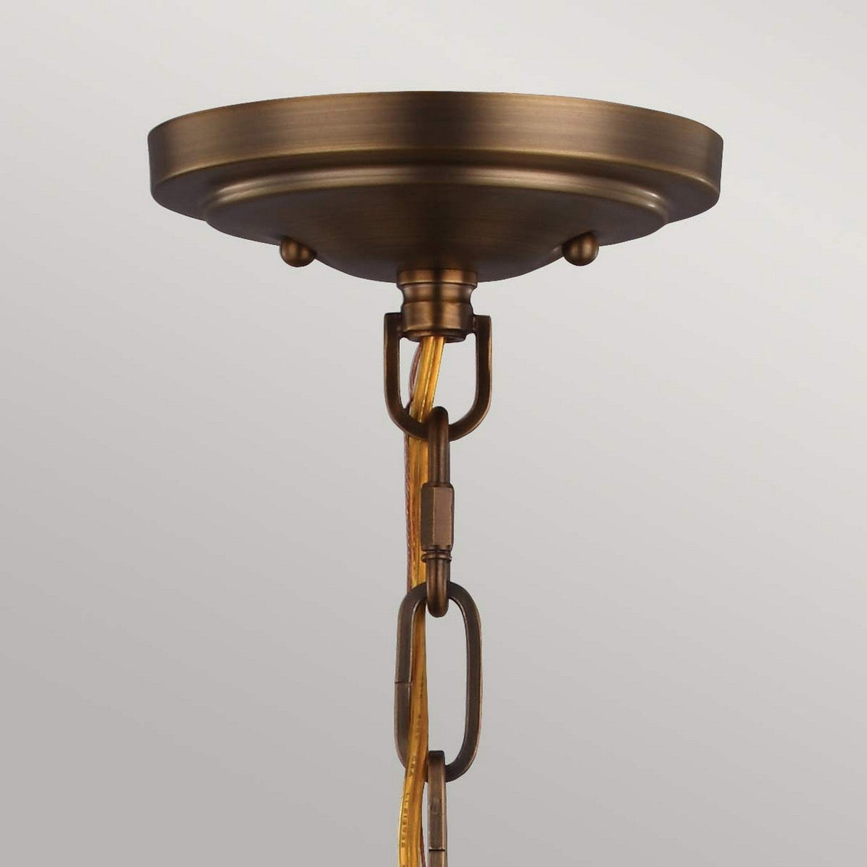 The Cadence 2 Light Pendant in Dark Antique Brass and Matte Black showcases its industrial pendant lighting with a centrally suspended chain and cord against a neutral backdrop. The fixture features an aged finish, enhancing the classic charm of its vintage-inspired design.