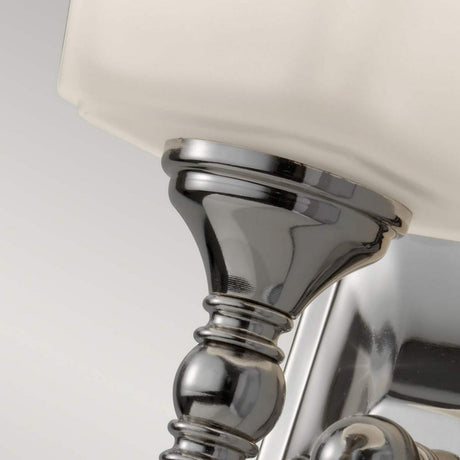 Close-up of the Concord 1 Light Wall Light - Polished Chrome, featuring an elegant metallic wall sconce with an opal-etched glass shade. The fixture boasts a polished chrome finish and detailed column design, set against a neutral background.