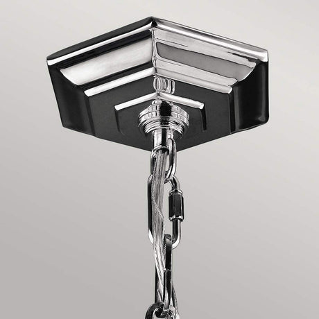 Close-up of a Corinne 3 Light Medium Chandelier in polished nickel, showcasing its minimalist elegance with a sleek and modern design against a plain gray background.