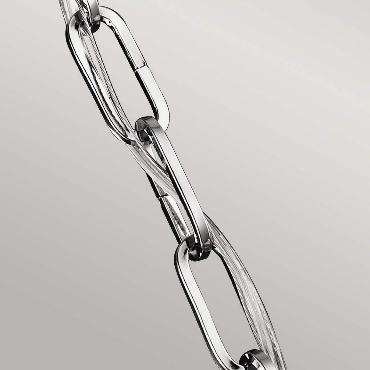Close-up of the Corinne 3 Light Small Chandelier, featuring a polished nickel finish with sleek elongated links, set against a light gray background.