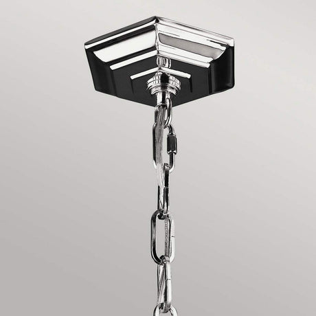 A close-up of the Corinne 6 Light Chandelier - Polished Nickel showcases modern elegance with a sleek metal chain. The square-shaped design with beveled edges, resembling polished nickel, supports the interconnected links of this future chandelier against a plain gray background.