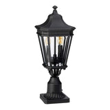 The Cotswold Lane 2 Light Outdoor Medium Light - Black is a vintage-style lantern featuring a square base and bevelled glass panes, showcasing two visible light bulbs inside. Its ornate, fluted design echoes the charm of antique gas lanterns, adding a touch of elegance to any space.