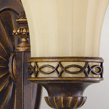 Close-up of the Drawing-1 Room 1 Light Wall Light in walnut, showcasing its vintage charm with a cream-colored, fluted glass shade and intricate bronze detailing. The metal features decorative patterns that echo Edwardian design, adding an elegant touch to any space.