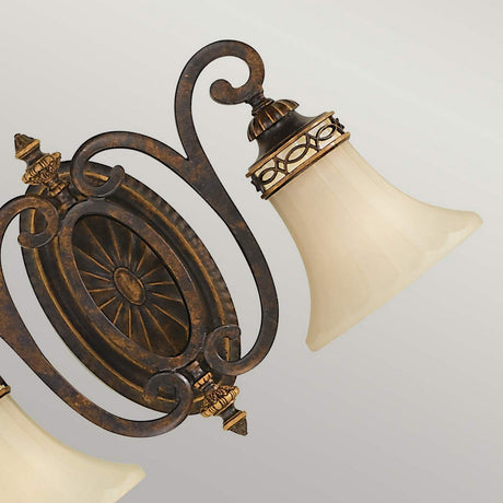 Introducing the Drawing-2 Room 2 Light Wall Light in Walnut: a decorative light fixture with an ornate metal design featuring intricate scrollwork, a central oval medallion, and fluted glass shades. Its walnut finish set against a neutral background exudes an elegant Edwardian style.