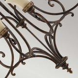 Close-up of a Drawing Room 9 Light Chandelier in a refined walnut finish, featuring ornate wrought iron scrollwork and cream-colored glass shades. The chandelier showcases traditional craftsmanship and Edwardian elegance against a neutral background.