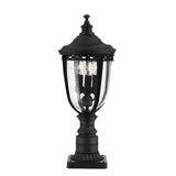The English Bridle 3 Light Outdoor Medium Pedestal - Black exudes a vintage style with its elegant black finish and clear seeded glass casing. The intricate details harmonize beautifully with the two visible light bulbs inside, enhancing the charm of any outdoor space.