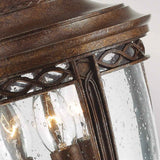 Here's a rephrased version of the sentence using the given product data:

Close-up of the English Bridle 3 Light Outdoor Medium Pedestal in Bronze, showcasing its vintage flair. The rain-speckled glass encases visible bulbs and is complemented by ornate detailing along the edges, enhancing its timeless elegance.