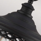 A detailed view of the English Bridle 3 Light Outdoor Medium Chain Lantern - Black showcases its vintage flair. This outdoor lighting fixture features a decorative top and a metal frame with intricate patterns, while its textured bubbled glass elevates its elegant design, adding timeless charm to any setting.