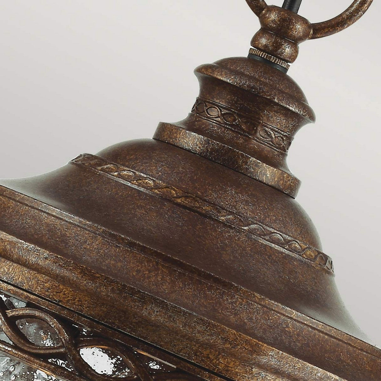 This close-up captures the English Bridle 3 Light Outdoor Medium Chain Lantern - Bronze, highlighting its vintage style and intricate detailing. The lantern features a bronze finish with clear glass panels, complemented by a curved top and a hanging loop, making it an ideal addition to enhance any outdoor space.