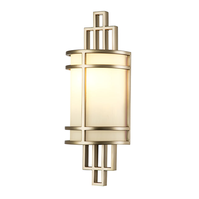 The Fusion 1 Light Wall Light - Painted Natural Brass features an Art Deco-inspired design with a geometric frame in painted natural brass and a ribbed opal glass shade. Its design is characterized by intersecting vertical and horizontal lines that create elegant symmetry, while its warm glow enhances the sophistication of any space.