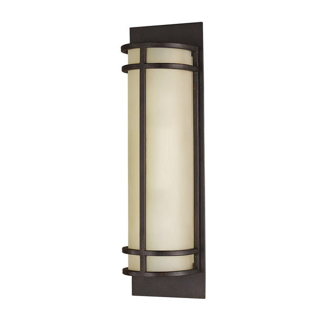 A modern vertical wall sconce featuring clean lines, a cylindrical amber glass shade, and a Grecian Bronze frame on a rectangular backplate, offering a soft, diffused lighting effect similar to the Fusion 2 Light Wall Light - Grecian Bronze.