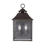 The Galena 2 Light Outdoor Half Lantern in Grey features a vintage-style design with a dark metal frame and clear glass pane. This outdoor half lantern accommodates two candle-like bulbs, offering classic elegance, and includes a loop at the top for convenient hanging—perfect for sophisticated exterior lighting.