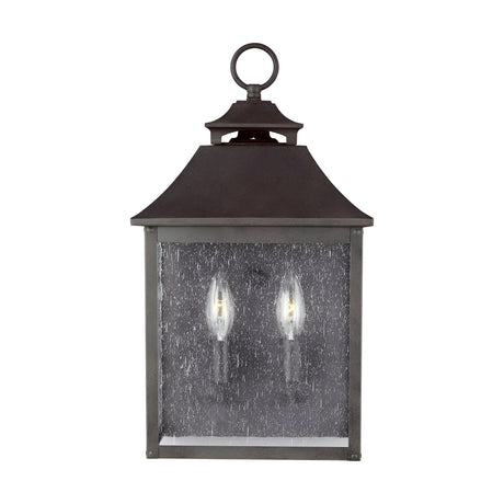 The Galena 2 Light Outdoor Half Lantern in Grey features a vintage-style design with a dark metal frame and clear glass pane. This outdoor half lantern accommodates two candle-like bulbs, offering classic elegance, and includes a loop at the top for convenient hanging—perfect for sophisticated exterior lighting.